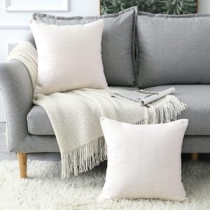 Coussin en lin blanc sur un lit dans une chambre de style farmhouse