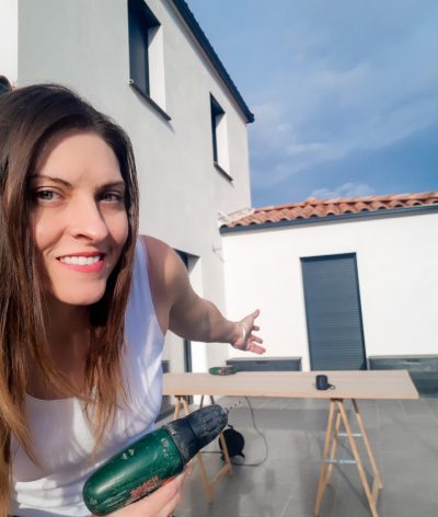 Stéphanie, fondatrice de DécoMindset, présentant un projet de rénovation DIY modern farmhouse devant sa maison.